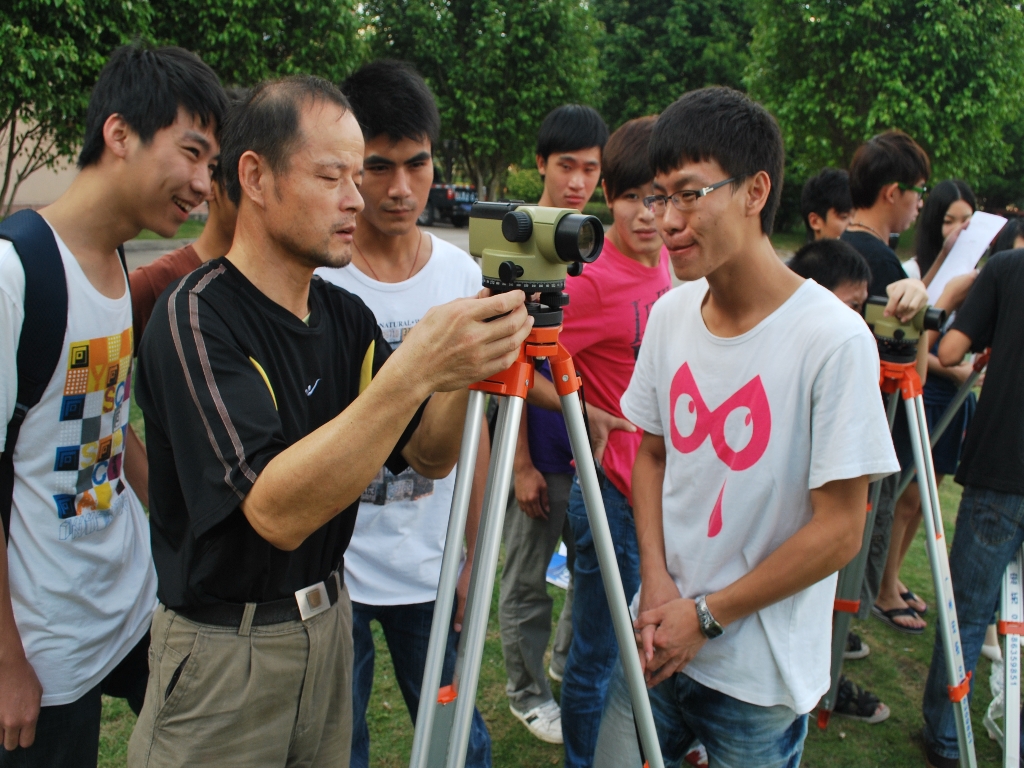 学院副院长在给学生示范测量仪器整平